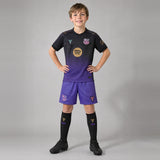 Enfant portant le kit FC Barcelone extérieur 2026/2027 : maillot, short et chaussettes