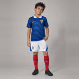 Enfant portant le kit France domicile Coupe du monde 2026 : maillot, short et chaussettes