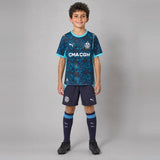 Enfant portant le kit OM extérieur 2026/2027 : maillot, short et chaussettes