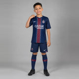 Enfant portant le kit PSG domicile Back to Back 2 étoiles : maillot, short et chaussettes